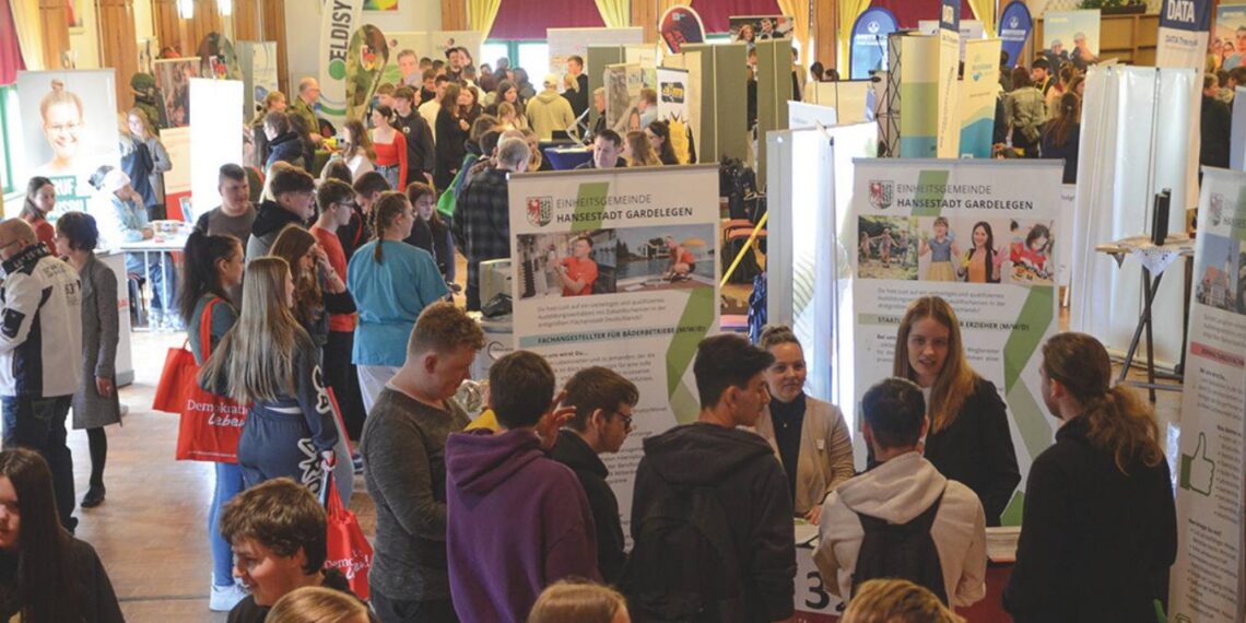 Schülerinnen und Schüler im Gespräch mit Auszubildenden und Unternehmensvertretern bei der Ausbildungsmesse „Zukunft jetzt – von Azubis für Azubis“ im LIW-Saal in Gardelegen, regionale Betriebe stellen Ausbildungsberufe vor.