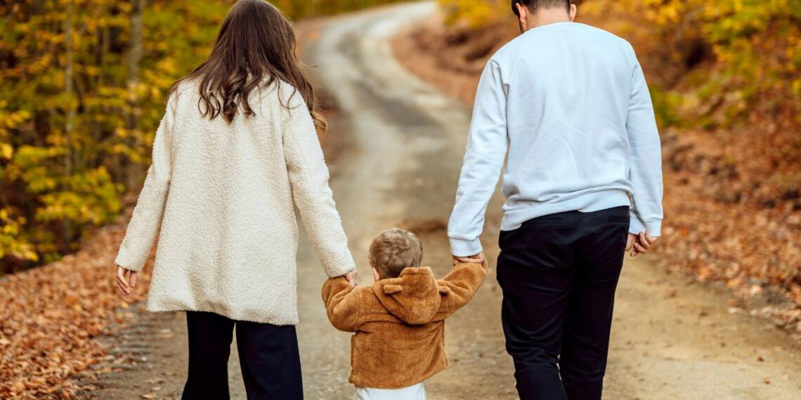 Pflegefamilie beim Spaziergang: Eltern gehen mit Pflegekind draußen in der Natur, Thema Pflegeelternschaft, Kinderbetreuung und Unterstützung durch das Jugendamt im Altmarkkreis Salzwedel.