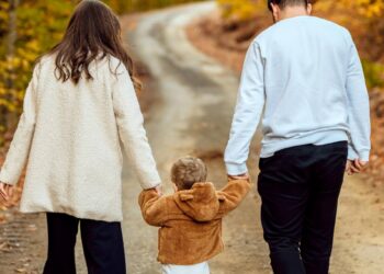 Pflegefamilie beim Spaziergang: Eltern gehen mit Pflegekind draußen in der Natur, Thema Pflegeelternschaft, Kinderbetreuung und Unterstützung durch das Jugendamt im Altmarkkreis Salzwedel.